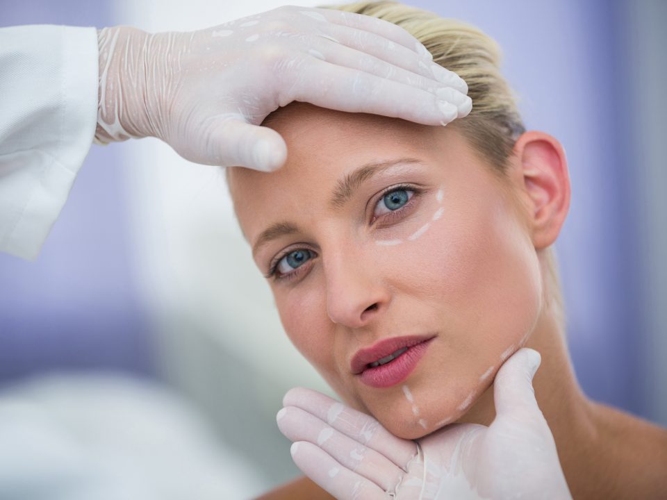 riscos de procedimentos faciais - édico examinar pacientes do sexo feminino enfrentar para tratamento cosmético